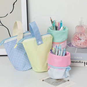 Close-up of pastel canvas pencil cases and standing pouches in a desktop setting