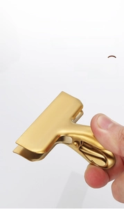 Close-up of golden brushed stainless steel T-shape clip showing thick metal texture