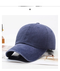 Detailed view of dark blue washed denim baseball cap with vintage distressed texture
