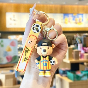 Detail of cartoon football bear mascot keychain with yellow Adorable strap and gold clasp