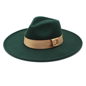 Close-up of wool fedora hat with beige ribbon and golden bee metal emblem detail