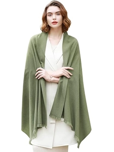 Detail of soft green faux cashmere shawl draped over a model for elegant winter warmth