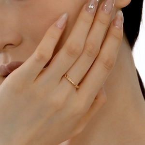 Detailed view of an 18K gold-plated twisted rope ring worn on a finger for daily styling