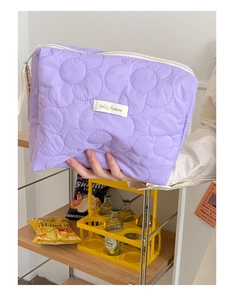 Vue détaillée d'une trousse à maquillage matelassée violette à motifs floraux