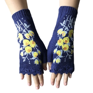 Blue knitted fingerless gloves with yellow floral embroidery and wavy ruffled cuffs