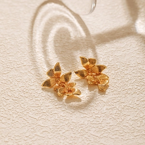 Macro shot of double-layered floral stud earrings with 18K gold plated texture