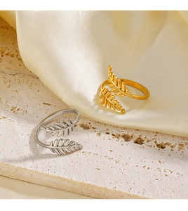 Dettaglio di anelli a foglia regolabili in oro 18K e argento su base in pietra