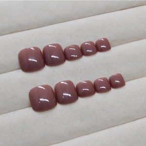 Glossy rose pink jelly press-on toe nails set on grey velvet display tray