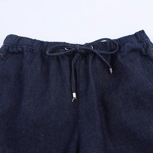 Détail du jogging en jean bleu foncé avec taille élastique et cordon à embouts en métal