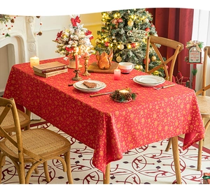 Detail of red Christmas tablecloth with golden snowflake and reindeer foil patterns