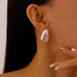 Gros plan de boucles d'oreilles goutte d'eau argentées sur un mannequin élégant