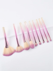 Close-up of pink gradient makeup brushes with soft synthetic bristles on white steps