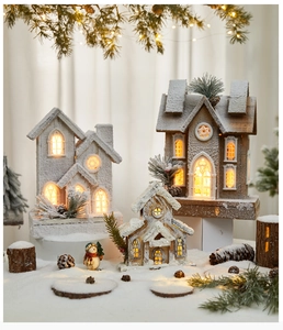 Detailed view of three glowing wooden Christmas houses with warm LED lights and faux snow decor