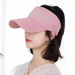 Detail of pink knitted visor with SPORT letter embroidery and breathable mesh texture