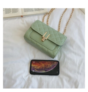 Detail of light green quilted crossbody bag with gold chain strap and metal lock