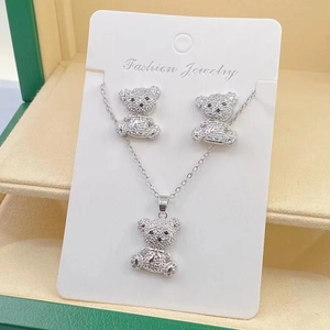 Detailed view of silver bear jewelry set with necklace and earrings in a green gift box