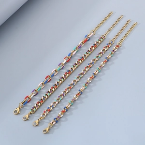 Macro view of four assorted 18K gold Cuban bracelets with colorful enamel inlay details