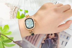 Close-up of elegant oval rose gold watch with green mica dial and diamond bezel