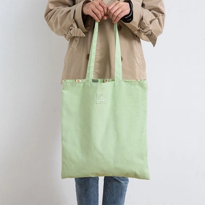 Mint green canvas tote bag with avocado print lining and woven label for shopping