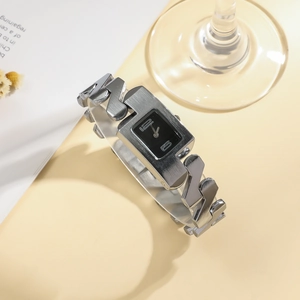 Detail of a minimalist square watch with silver metal chain links and black dial