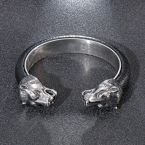 Detailed view of punk lion head ends and textured leather band on a steel bracelet