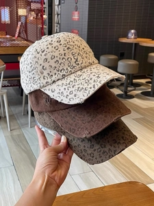 Close-up of leopard print baseball caps with vintage distressed and frayed edge details