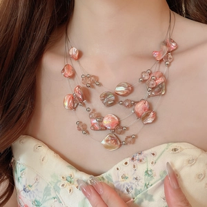 Detailed view of layered iridescent pink shell beads and crystal pendant necklace for women