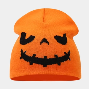 Close-up of the knitted orange beanie featuring a black woven Jack-o'-lantern pumpkin face