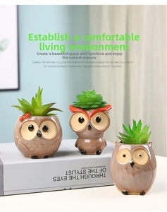 Three owl-shaped ceramic succulent pots with hand-painted glaze details on a desk