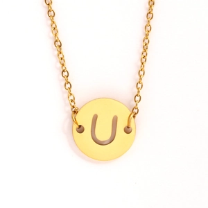 Détail du collier en acier inoxydable doré avec un pendentif rond ajouré lettre U