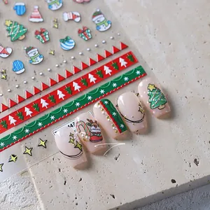 Macro view of Christmas nail art stickers featuring trees and snowmen on nude nails