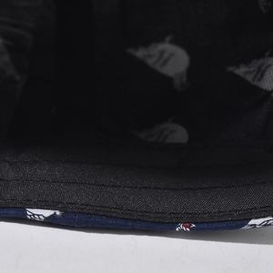 Detail of multi-row stitching on brim and skull print lining of navy cotton sun hat