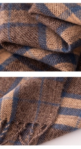 Detailed macro view of the blue and brown plaid scarf fabric texture and fringe tassels