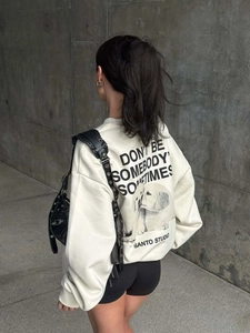 Vue extérieure d'un sweat crème avec motif chien et slogan imprimé dans le dos