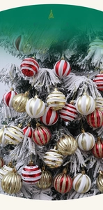 Close-up of red and white striped Christmas ornament balls hanging on a snowy tree