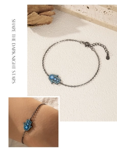 Detail of Hamsa Hand and Evil Eye bracelet with dark silver plating and turquoise stones