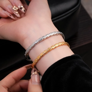 Détail macro du bracelet plaqué or 18k avec motifs croisés et micro-incrustations de zircons