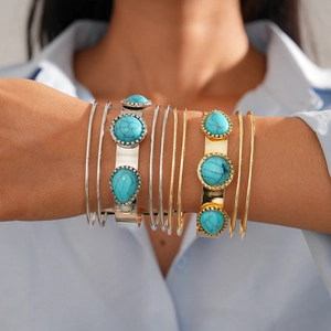Detail of layered gold and silver bangles with turquoise marble stones on model