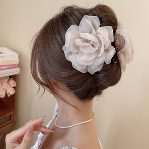 Detailansicht einer großen beige Organza-Blumen-Haarklammer auf einer edlen Hochsteckfrisur