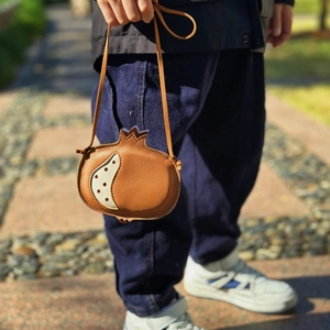 Detailed view of pomegranate shaped leather crossbody bag for kids with litchi texture