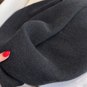 Close-up of thick black faux cashmere scarf texture showing soft woolen material detail