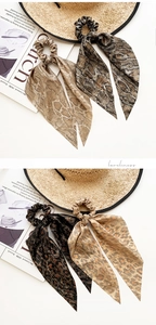 Detail view of animal print satin scrunchies with long ribbons in leopard and snake patterns