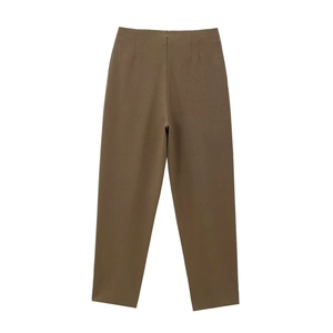 Dettaglio dei pantaloni a palloncino a vita alta in tessuto marron scuro con pieghe