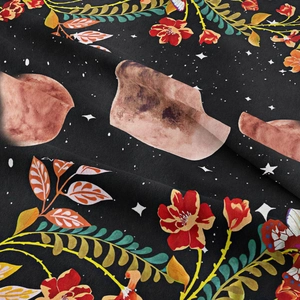 Close-up of bohemian floral tapestry fabric showing soft texture and detailed moon patterns