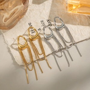Detail of elegant gold and silver geometric fringe earrings with long chain tassels