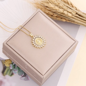 Gold plated Virgin Mary necklace with zircon halo on jewelry box with wheat decor