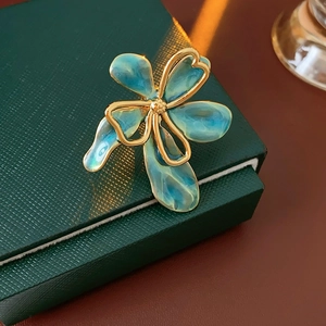 Macro view of vintage lake blue enamel flower ring on a dark green jewelry box