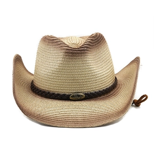 Detail of western straw cowboy hat with gradient finish and bull emblem leather band