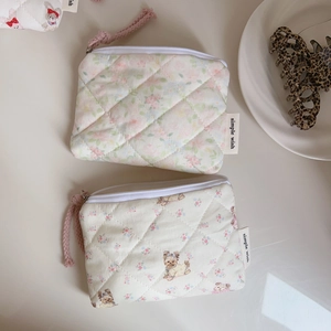 Close-up of quilted floral coin purses with zipper detail and soft fabric texture