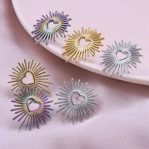 Macro detail of heart-shaped sunburst earrings in gold, silver, and iridescent finishes